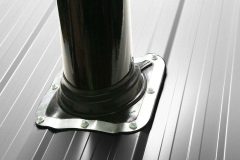Eight screws holding ArcticVent to black steel roof