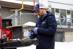 Contractor cutting Cut-to-length heat trace cable from reel on tailgate