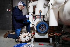 Contractor installing external self-regulating heat trace system on pipe indoors
