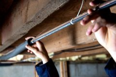Hands holding pipe with Paladin and Insulation installed on pipe