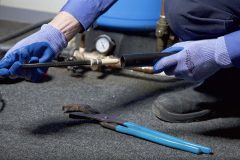Gloved Hand Inserting Retro-Line Heating Cable into Pipe